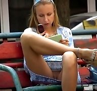 Voyeur upskirt pussy of blonde amateur playing with a phone